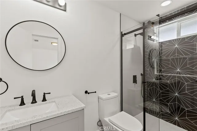 a bathroom with a sink and mirror with toilet