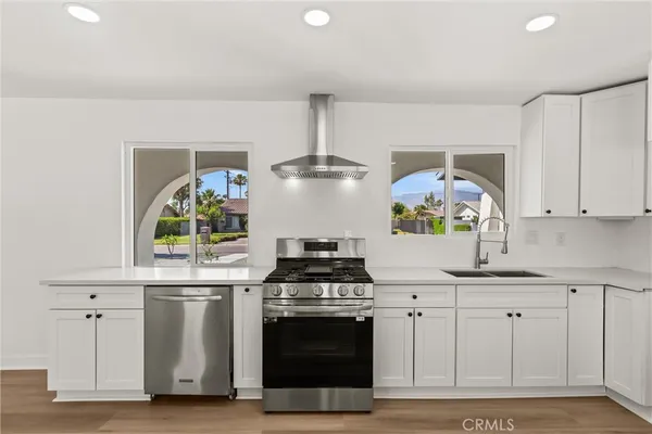 a kitchen with white cabinets and appliances