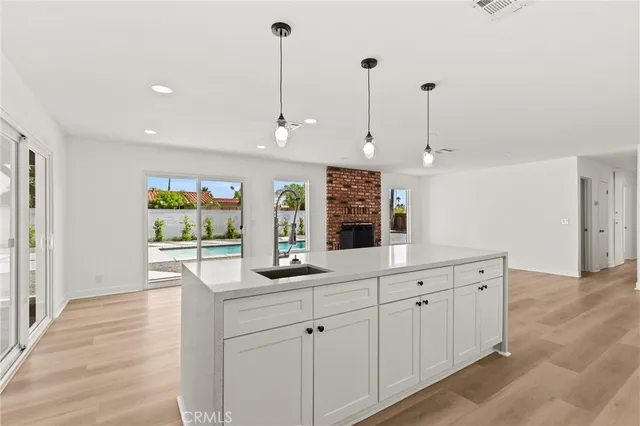 a kitchen with white cabinets and window