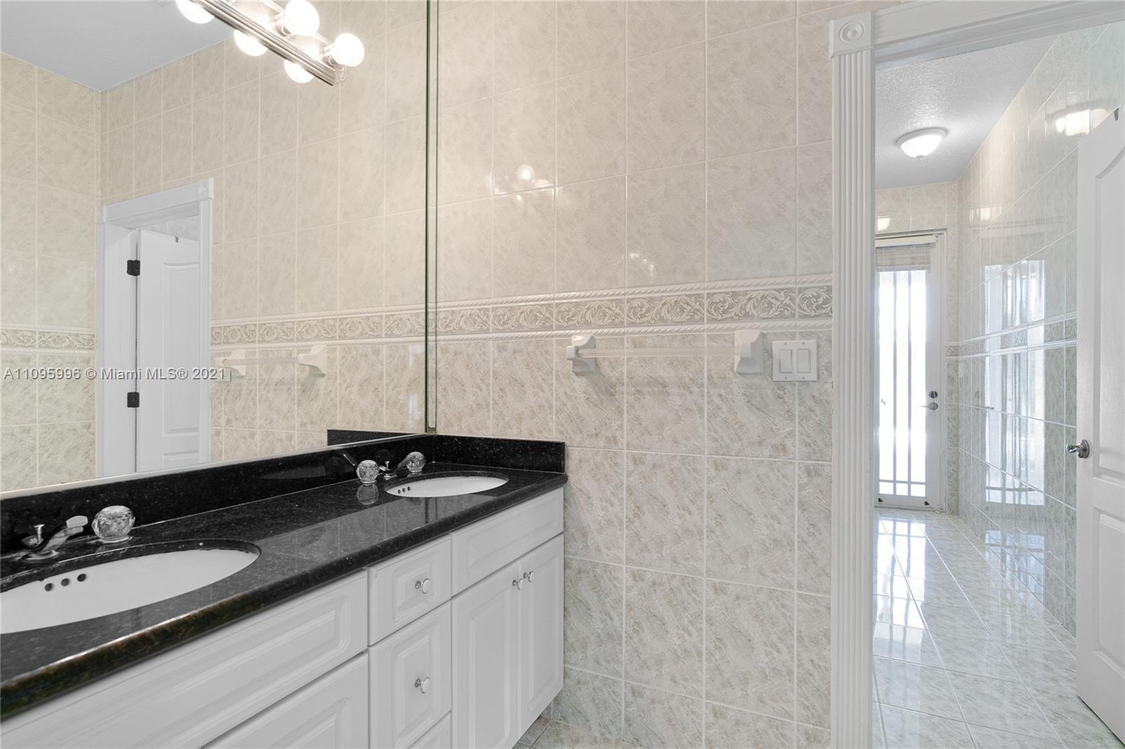 3671 Southwest 139th Court Miami, FL 33175 - Photo 14 of 56 a bathroom with a granite countertop sink and a mirror
