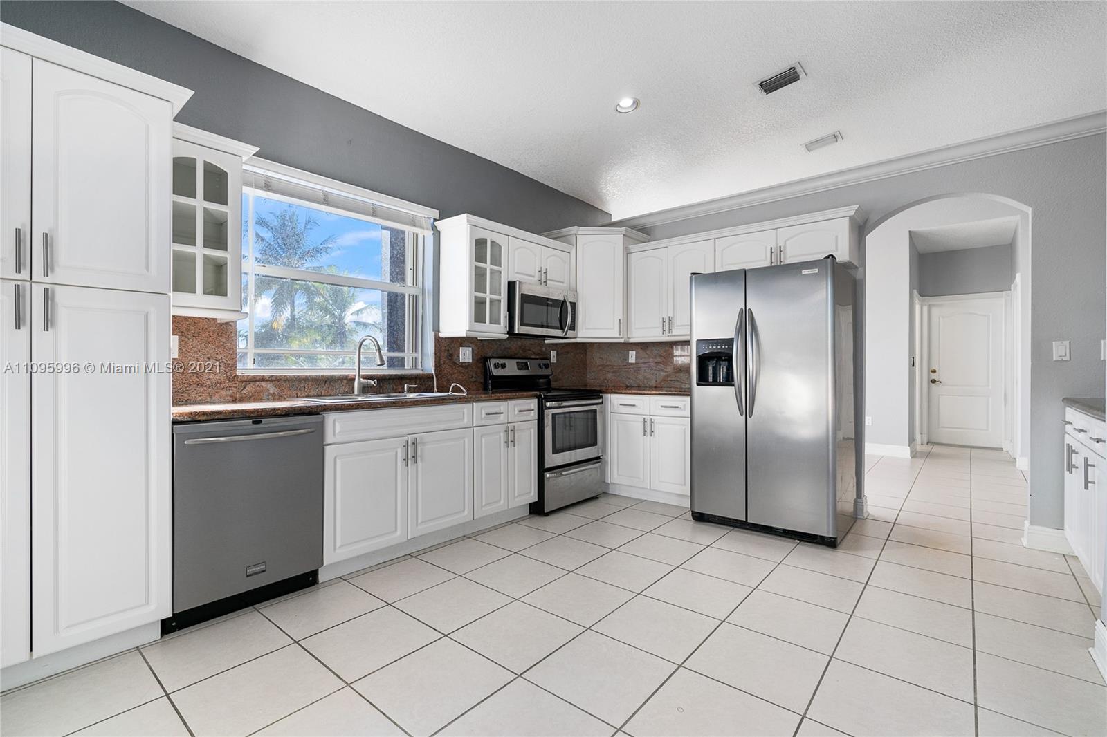 3671 Southwest 139th Court Miami, FL 33175 - Photo 40 of 56 a kitchen with stainless steel appliances granite countertop a refrigerator and a stove top oven