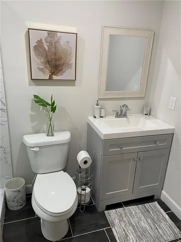a bathroom with a toilet a sink and mirror