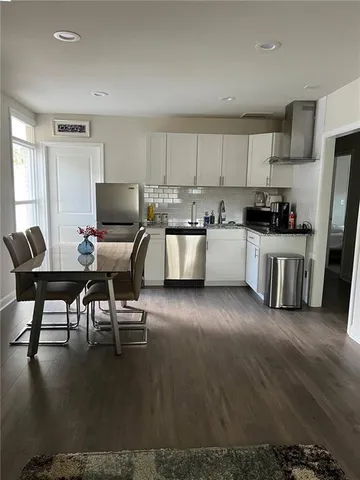 a kitchen with a table chairs microwave and cabinets