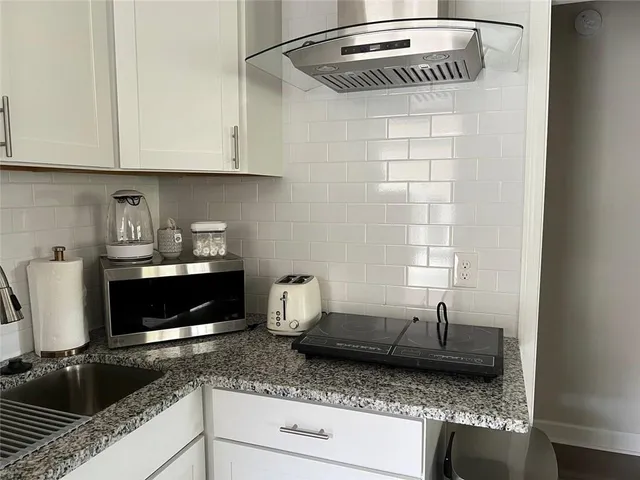 a kitchen with granite countertop stainless steel appliances a stove a sink and a microwave