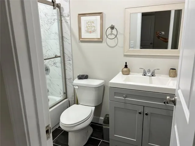 a bathroom with a toilet sink and mirror