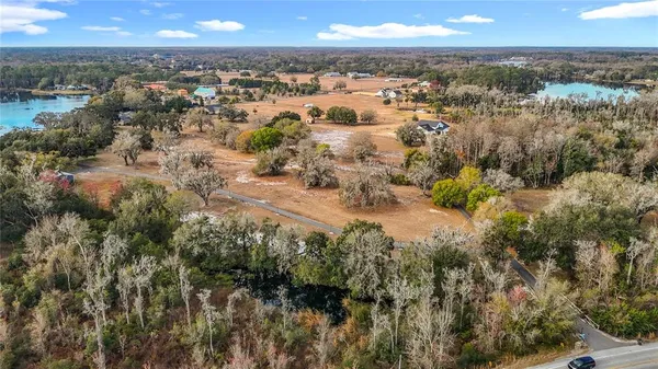 an aerial view of house with yard and mountain view in back