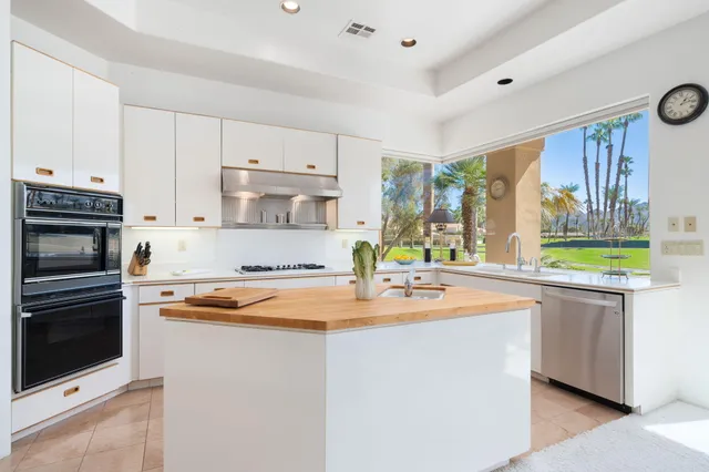 a large white kitchen with a large window