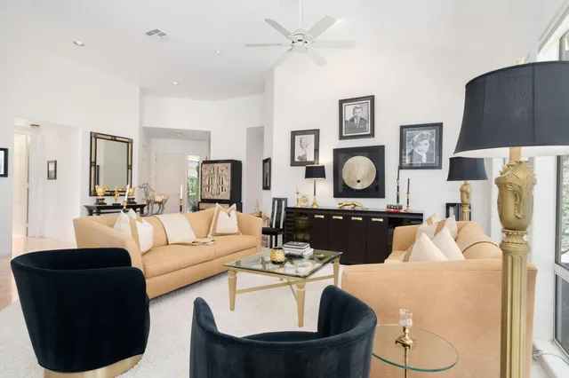 a living room with furniture kitchen view and a chandelier