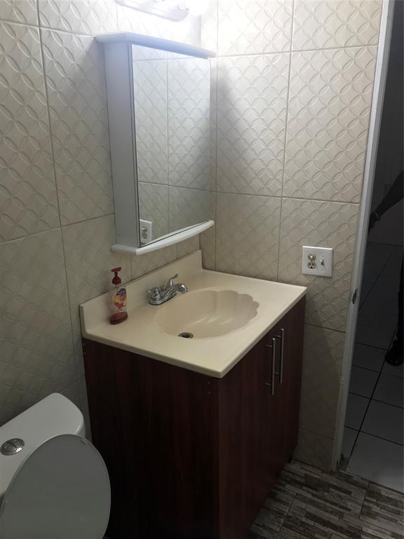 161 Northwest 164th Street, Unit 3 Miami, FL 33169 - Photo 2 of 8 a bathroom with a sink toilet and vanity
