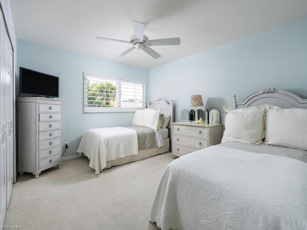 8846 Ventura Drive Naples, FL 34109 - Photo 11 of 18 a bedroom with bed tv and a window