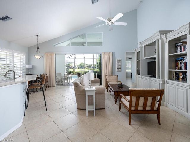 a dining room with furniture and a floor to ceiling window