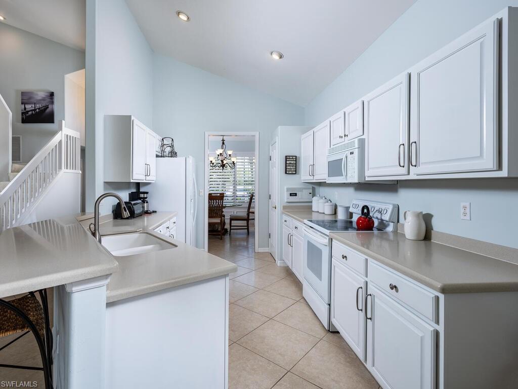 8846 Ventura Drive Naples, FL 34109 - Photo 5 of 18 a kitchen with stainless steel appliances granite countertop a sink and cabinets