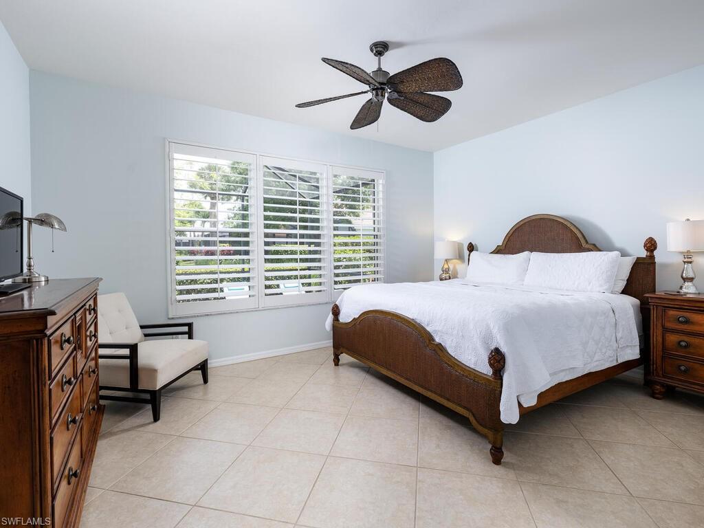 8846 Ventura Drive Naples, FL 34109 - Photo 7 of 18 a bedroom with a bed and a chandelier