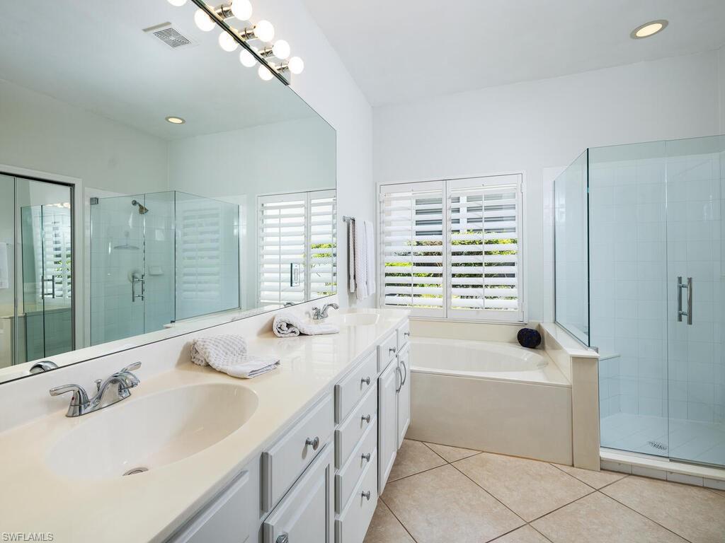 8846 Ventura Drive Naples, FL 34109 - Photo 8 of 18 a bathroom with a tub sink and mirror