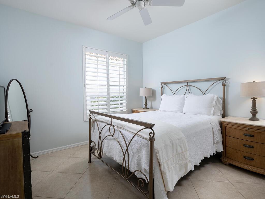 8846 Ventura Drive Naples, FL 34109 - Photo 9 of 18 a bedroom with a bed and a dresser next to a window