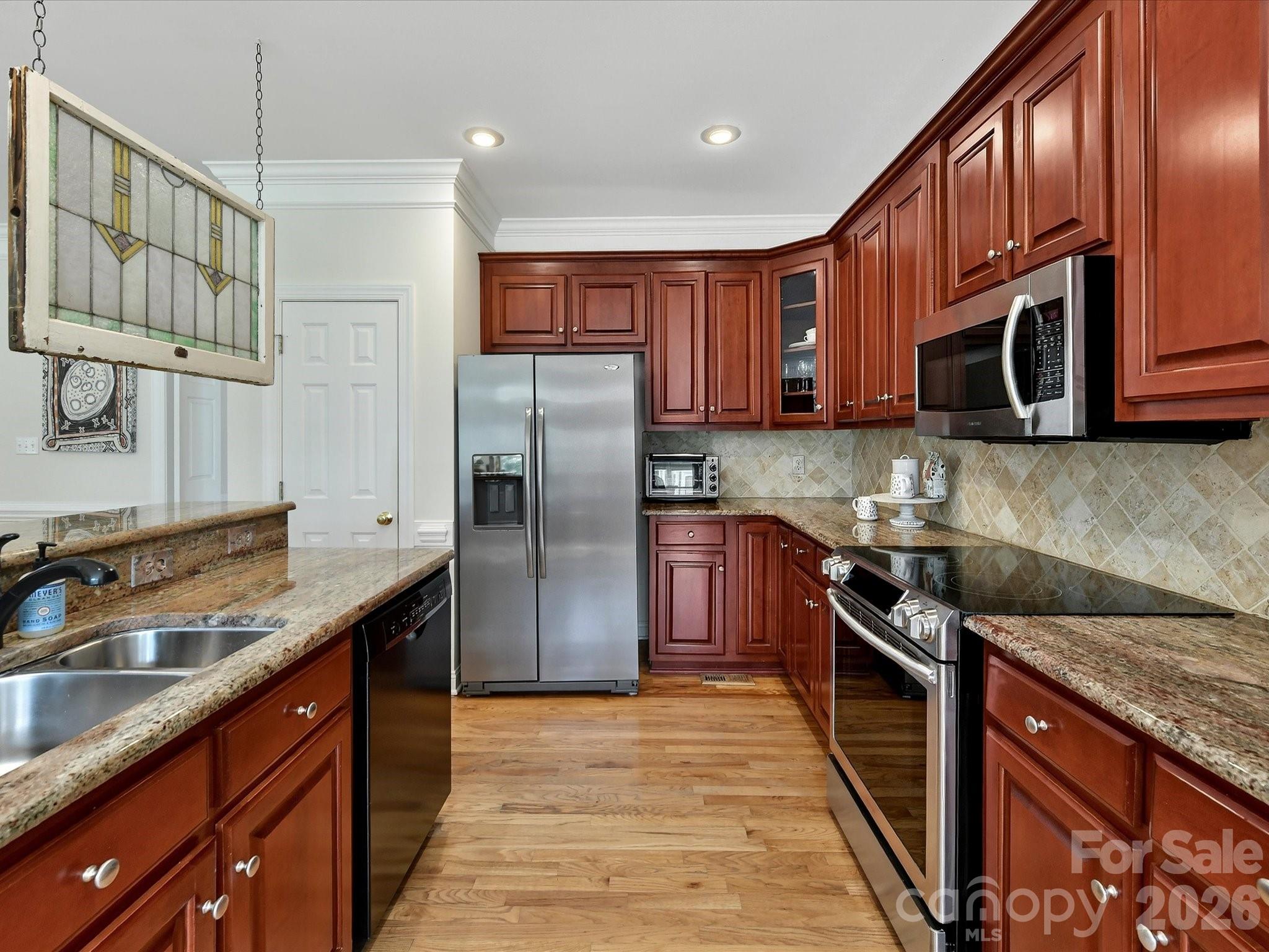 207 Hobbs Street Davidson, NC 28036 - Photo 15 of 40 a kitchen with stainless steel appliances granite countertop a stove a sink dishwasher a refrigerator and cabinets with wooden floor