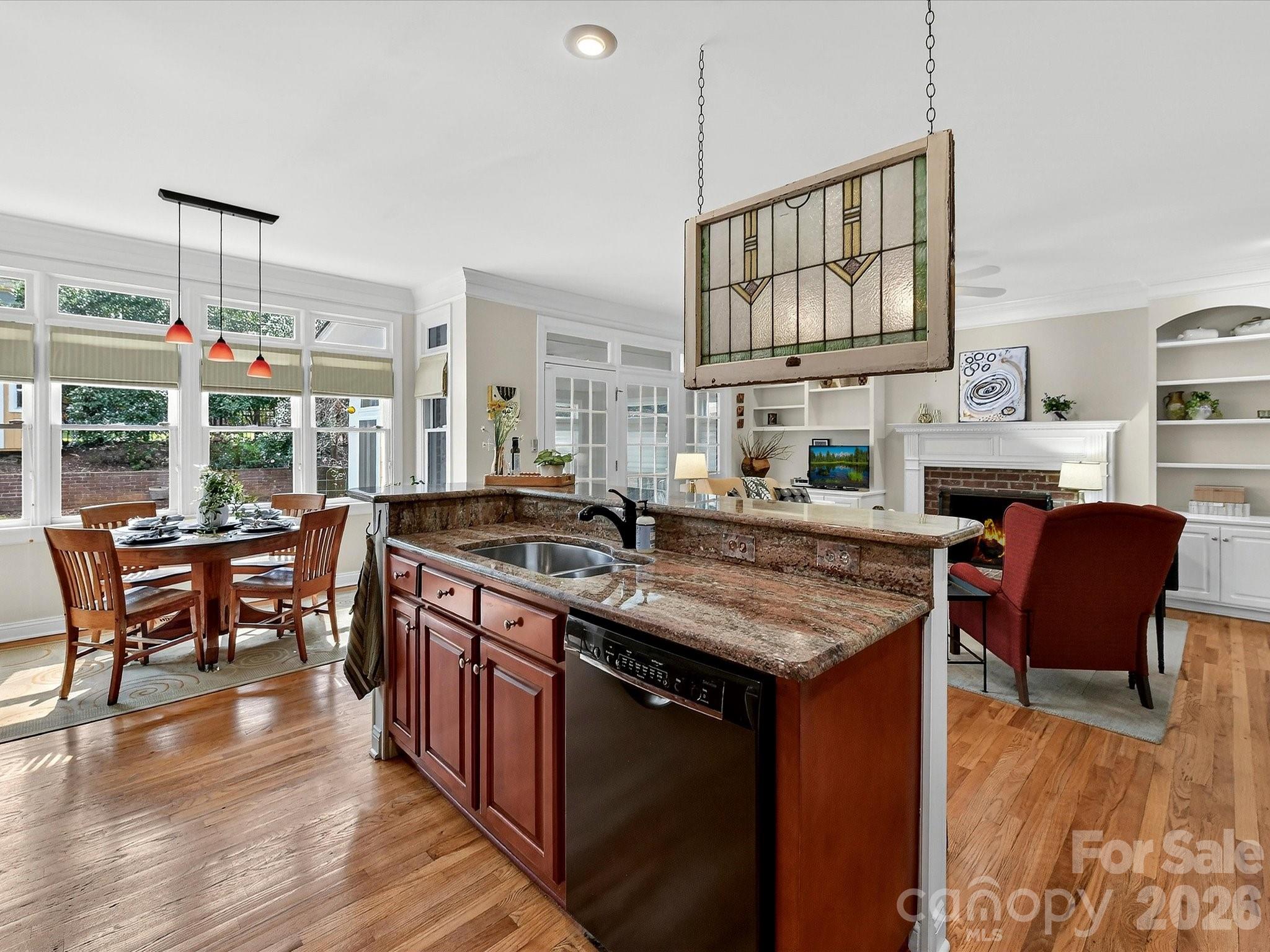 207 Hobbs Street Davidson, NC 28036 - Photo 16 of 40 a kitchen with stainless steel appliances granite countertop a stove top oven a dining table and chairs with wooden floor