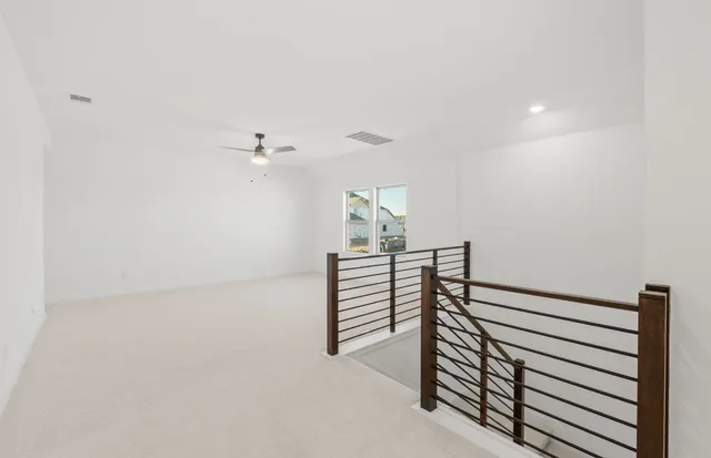 en empty room with stairs and windows