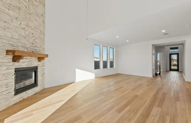 a view of an empty room with a fireplace and a window