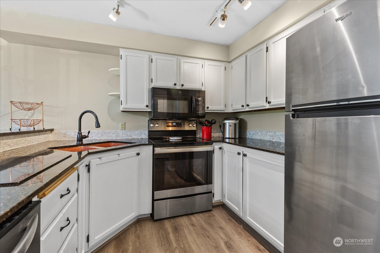 19316 Bothell Way Northeast, Unit C203 Bothell, WA 98011 - Photo 10 of 27 a kitchen with granite countertop a sink stainless steel appliances and white cabinets