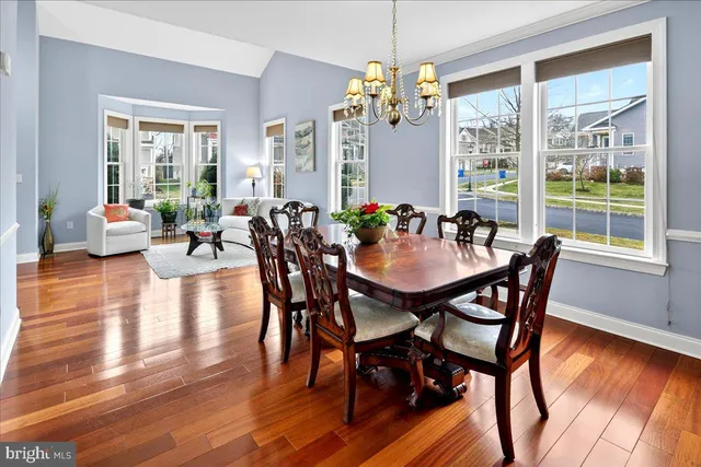 a view of a dining room with furniture wooden floor and chandelier