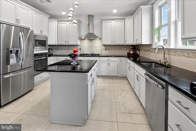 a kitchen with stainless steel appliances granite countertop a sink refrigerator and cabinets