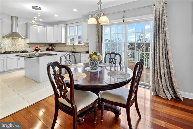 a kitchen with granite countertop a dining table chairs and white cabinets