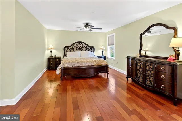 a spacious bedroom with a bed and wooden floor