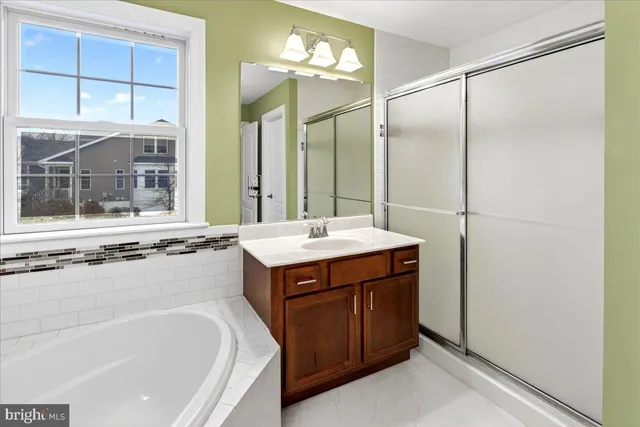 a bathroom with a tub sink and mirror