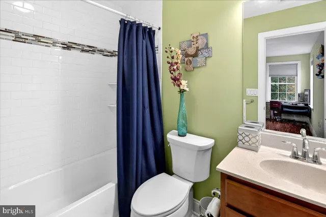 a bathroom with a sink a toilet a mirror and shower