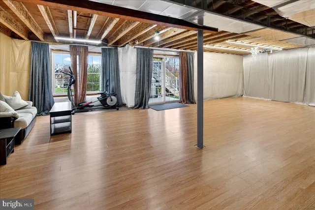 a view of empty room with wooden floor and windows