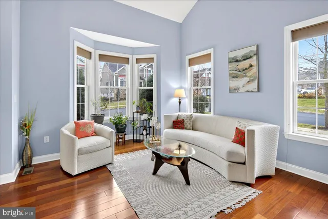 a living room with furniture and a large window with wooden floor