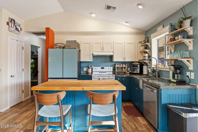 a kitchen with stainless steel appliances kitchen island granite countertop a table and chairs in it