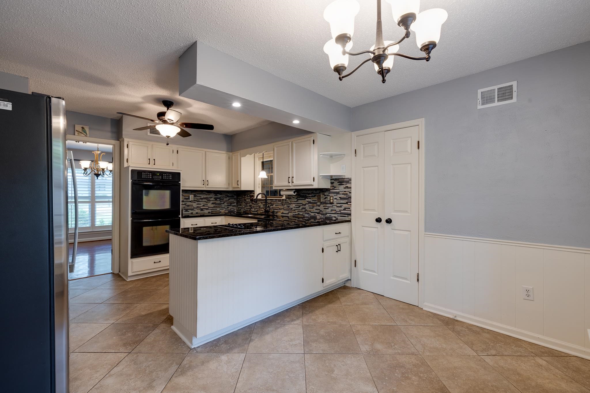 2026 Sunset Road Germantown, TN 38138 - Photo 7 of 28 Kitchen with freestanding refrigerator, a chandelier, dark countertops, a sink, and a peninsula
