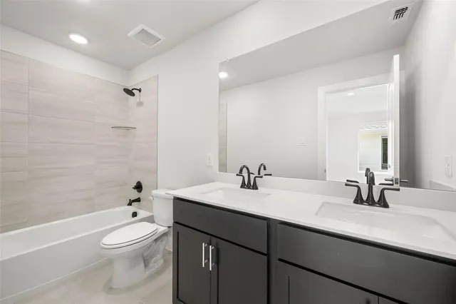 a bathroom with a toilet a sink a tub and mirror