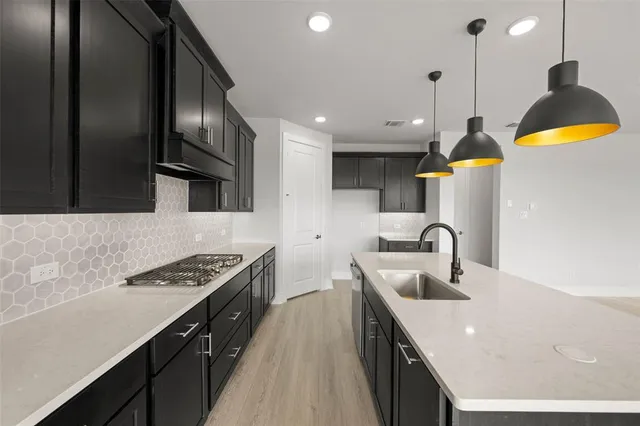 a kitchen with stainless steel appliances granite countertop a sink a stove and a refrigerator