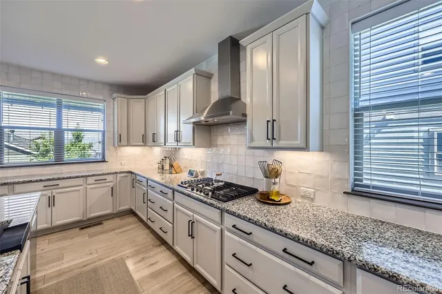 a kitchen with granite countertop a sink stainless steel appliances and window