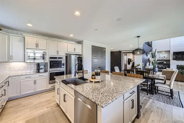 a kitchen with stainless steel appliances granite countertop a kitchen island sink stove and cabinets