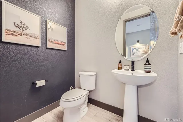 a bathroom with a toilet a sink and mirror