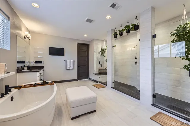 a bathroom with a tub sink shower and mirror
