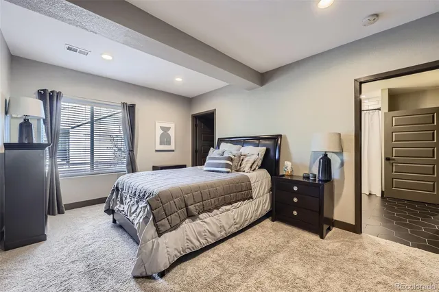 a bedroom with a bed and dresser with mirror