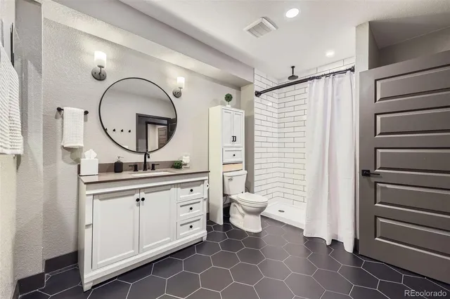 a bathroom with a toilet a sink and a mirror