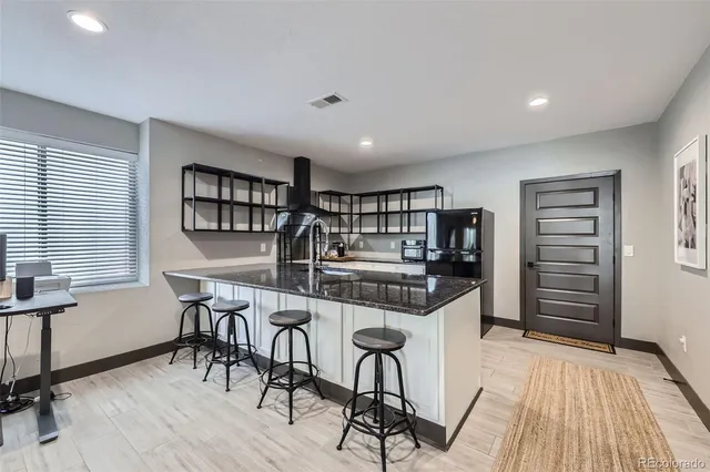 a kitchen with stainless steel appliances a table and chairs in it
