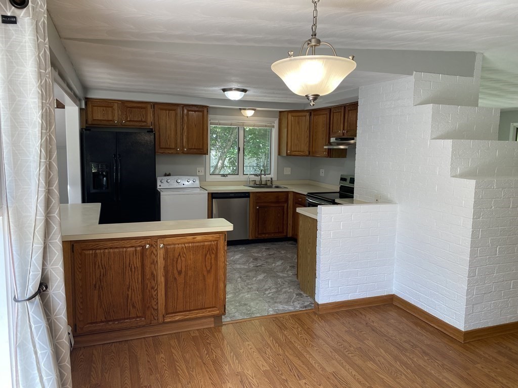 28 Savoy Road Framingham, MA 01701 - Photo 6 of 42 a kitchen with stainless steel appliances granite countertop wooden cabinets a stove a sink and a refrigerator