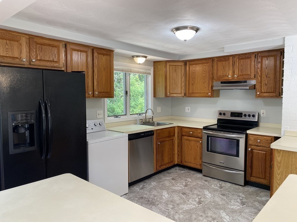28 Savoy Road Framingham, MA 01701 - Photo 10 of 42 a kitchen with granite countertop a refrigerator stove top oven a sink and dishwasher