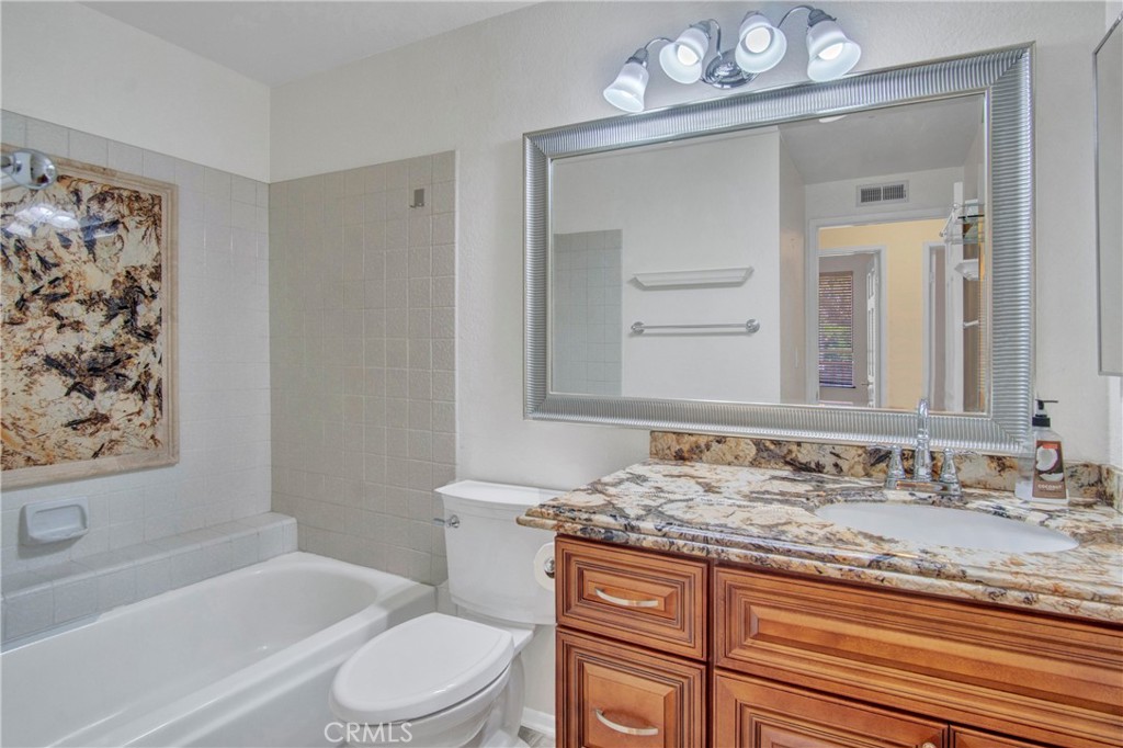 2571 Plaza Del Amo, Unit 107 Torrance, CA 90503 - Photo 15 of 33 a bathroom with a granite countertop sink toilet a mirror and bathtub