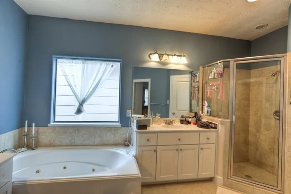 a bathroom with a tub a sink and a window