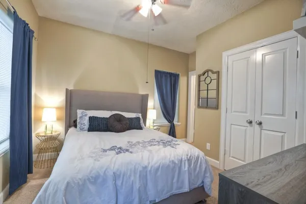 a bedroom with a large bed and a chandelier