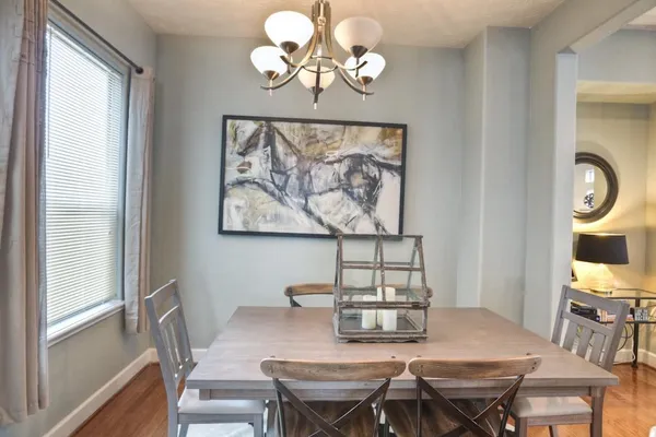 a view of a dining room with furniture wooden floor and a chandelier