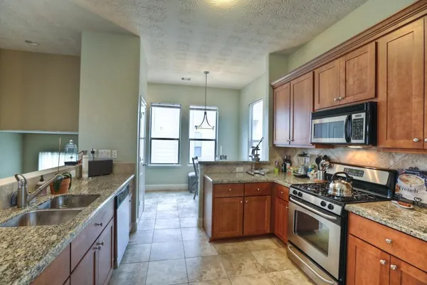 a kitchen with stainless steel appliances granite countertop a sink stove and cabinets